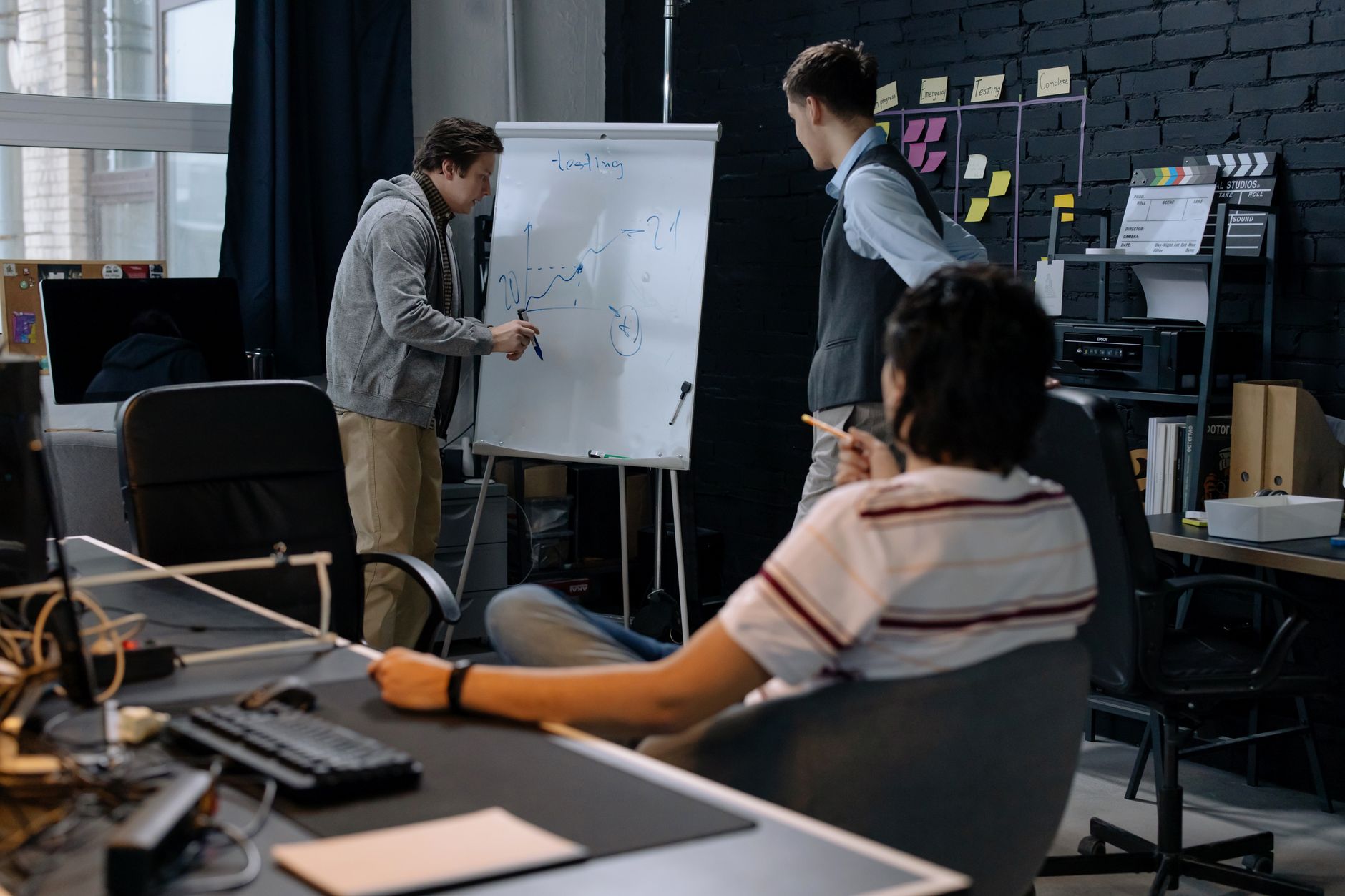Plusieurs personnes réunies dans un bureau autour d’un tableau blanc présentant un graphique.
